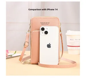 Detail view of pink crossbody phone bag sized against an iPhone 14 for scale comparison