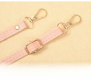 Detail of pink lychee leather strap with polished golden lobster clasps and hardware