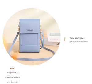 Détail de la pochette téléphone bleu clair avec logo doré et bandoulière réglable