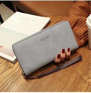Detail of light blue-grey long zipper wallet with wrist strap and textured finish