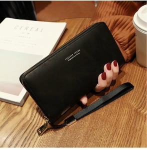 Detail of a black long zippered wallet in soft PU leather with a gold metal zipper