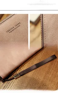 Close-up of pink long wallet with grainy texture and golden Forever Young logo engraving