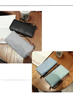 Detailed view of women long zipper wallets in four colors on a wooden table with hand strap