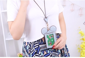 Light blue Mickey silhouette card holder with matching neck lanyard worn over white t-shirt