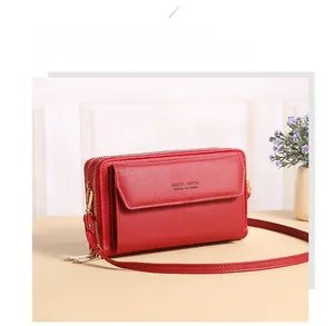Detail of red crossbody phone bag with gold Forever Young logo and smooth zipper