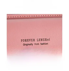 Detailed macro view of pink lychee grain leather texture and metallic gold logo print
