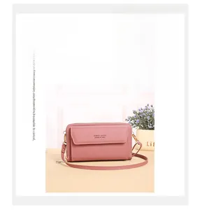 Detail of pink crossbody bag showing reinforced stitching and debossed logo on faux leather