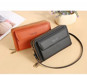 Close-up of black and orange faux leather crossbody bags with double zipper detailing