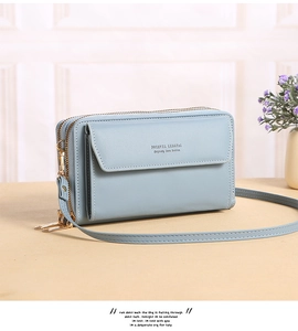 Detail view of light blue crossbody bag with multi-zipper layers and front flap pocket