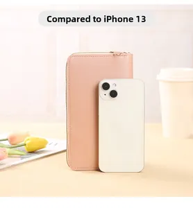 Peach touch screen crossbody bag shown side by side with iPhone 13 for size comparison