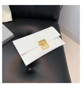 Detail of white rectangle clutch bag with crocodile texture and gold geometric buckle