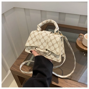 Dettaglio del motivo Triomphe in tela marrone e del manico in pelle beige della borsa