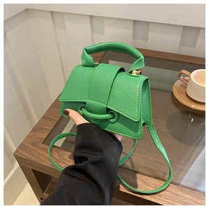 Dettaglio della piccola borsa quadrata verde in pelle litchi con fibbia decorativa
