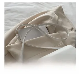 Détail de la bandoulière réglable en cuir blanc et boucle métallique argentée