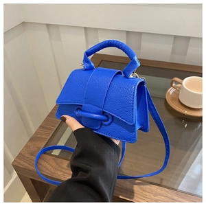 Dettaglio della mini borsa a tracolla blu reale in pelle martellata con manico rotondo