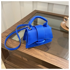 Dettaglio mini borsa blu elettrico con trama a litchi e finiture metalliche dorate