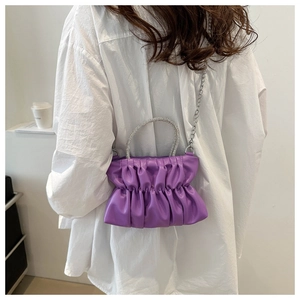Detail of lavender pleated crossbody bag with a sparkling rhinestone handle and silver chain