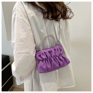 Détail du sac plissé violet avec poignée en strass et bandoulière en chaîne
