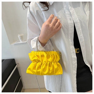 Détail du sac à main jaune plissé avec poignée en strass brillants et chaîne