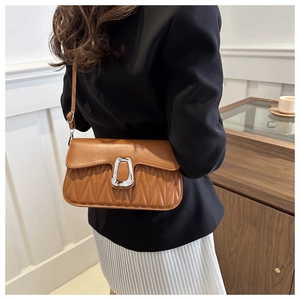 Détail du sac bandoulière marron plissé avec un fermoir métallique rectangulaire argenté