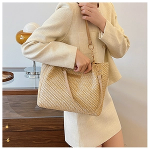 Women's woven straw tote bag in beige with faux leather strap and fashion label