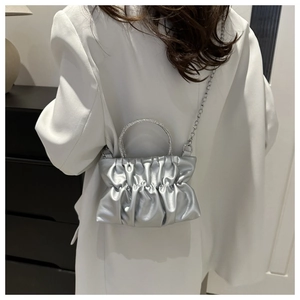 Detailed back view of a silver pleated cloud bag with a sparkling diamond handle