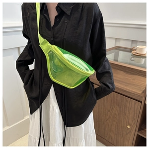 Neon green transparent PVC waist bag worn across the chest on a black top