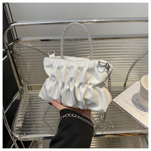 Détail du sac nuage blanc plissé avec poignée en strass étincelants et chaîne argentée