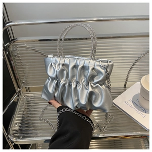 Détail du sac plissé argenté avec poignées rondes serties de strass et bandoulière chaîne