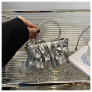 Détail d'un sac à main plissé argenté avec poignée en strass et bandoulière en chaîne