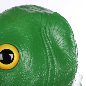 Detail shot of green latex fish mask showing textured scales and bright yellow eyes