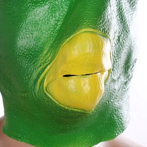 Close-up of green latex fish mask showing textured skin and yellow mouth opening