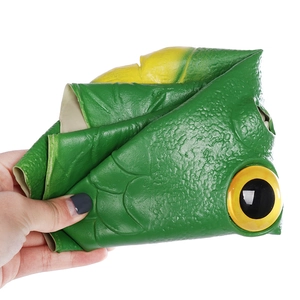 Close-up of flexible green fish monster mask showing realistic skin texture and yellow eye