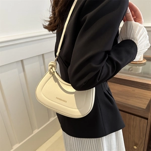 Beige half-moon crossbody bag with quilted details and knot shoulder strap