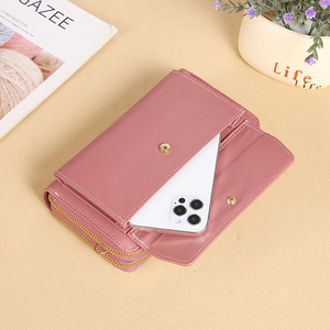 Pink crossbody phone bag with double zippers and contrast stitching in a 45-degree view