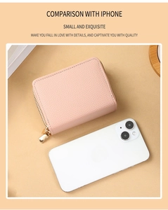 Close-up of pink litchi grain leather wallet with gold zipper next to an iPhone
