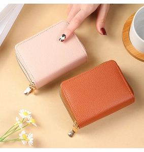 Close-up of litchi grain PU leather card holders in pink and tan with gold zippers