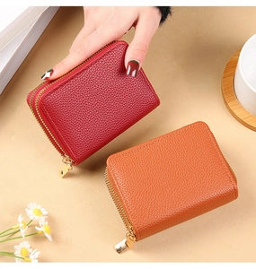 Detail of red and caramel lychee pattern leather card holders with gold zippers