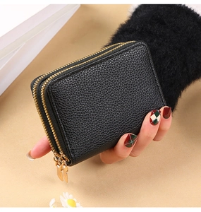 Close-up of a black litchi pattern PU leather card holder with double gold zippers
