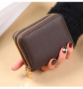 Close-up of a hand-held dark brown lychee textured PU leather wallet with dual zippers