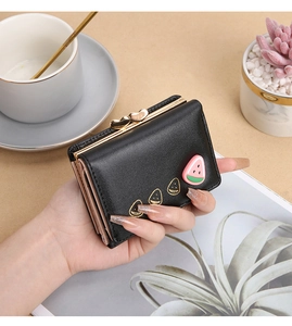 Detalle de la cartera corta de piel sintética con cierre de corazón y decorado frutal.