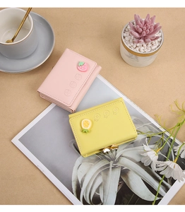 Bonito monedero mini plegable de cuero PU con detalle de colgante encantador vista cerca.