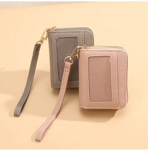 Détail du porte-cartes en cuir grainé avec fenêtre ID et dragonne pratique
