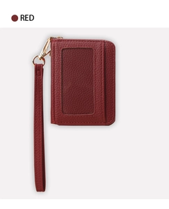 Détail d'un porte-cartes rouge grainé avec fenêtre transparente et sangle à crochet