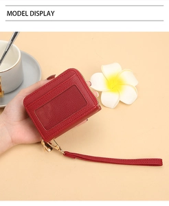 Détail du porte-cartes rouge en cuir avec fenêtre transparente et fermeture éclair dorée