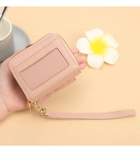 Vue détaillée du porte-cartes en cuir rose avec fenêtre d'identité et dragonne pratique