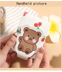 Close-up of cute cartoon bear and cherry pattern on white faux leather lipstick case