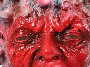 Dettaglio della maschera virus in lattice rosso con trama muscolare e punte rigide