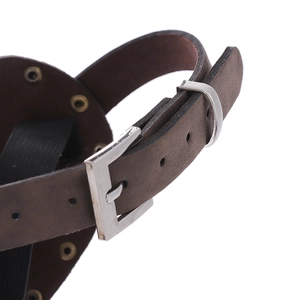 Détail d'une sangle marron réglable avec boucle en métal et rivets sur masque punk