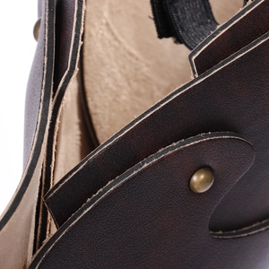 Detailed macro view of dark brown faux leather with bronze rivets and textured surface